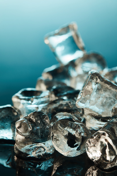 selective focus of transparent ice cubes on emerald background - Fotó, kép