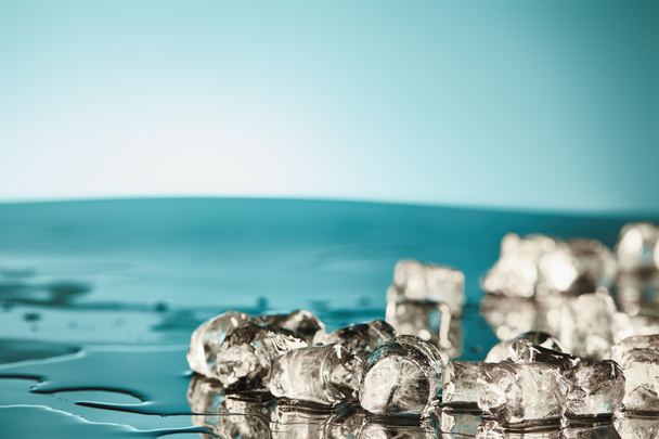 transparent melting ice cubes on emerald and white background - Fotoğraf, Görsel