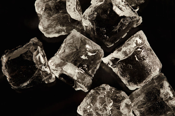 stapel transparante koele ijsblokjes geïsoleerd op zwart  - Foto, afbeelding