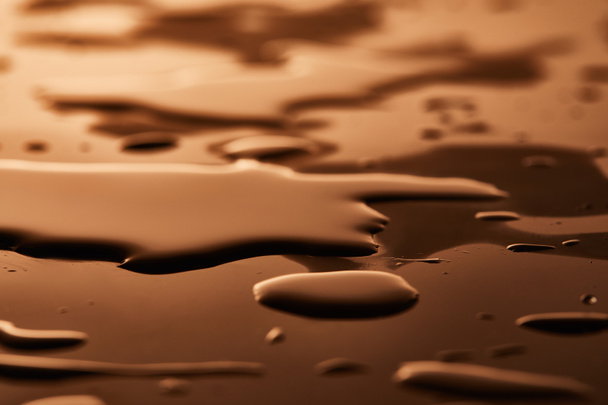 茶色の背景に水たまりと滴 - 写真・画像
