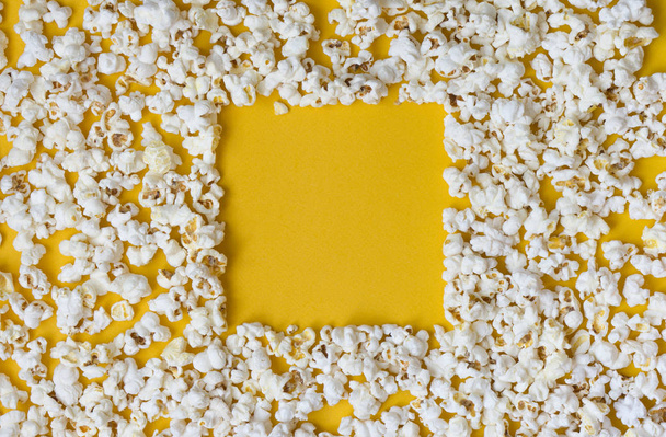 White popcorn on a yellow background. - Foto, afbeelding