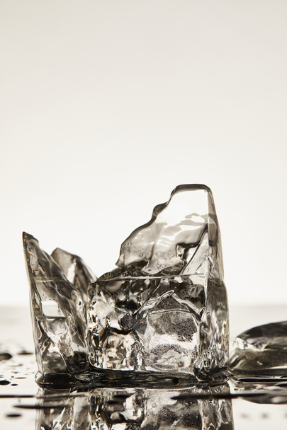 transparent melting ice cubes with drops and puddles on white background - Photo, Image