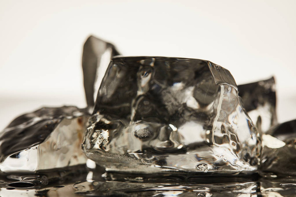 close-upweergave van transparante smeltende ijsblokjes op witte achtergrond - Foto, afbeelding