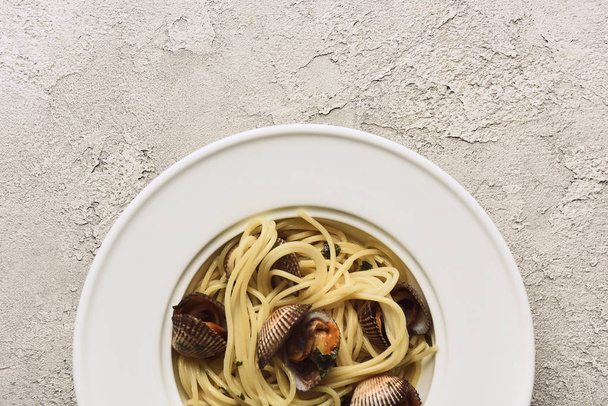 верхний вид вкусной пасты с моллюсками на белом текстурированном фоне
 - Фото, изображение