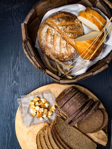 breads in baskets, variety baking products on wooden surface - Photo, Image