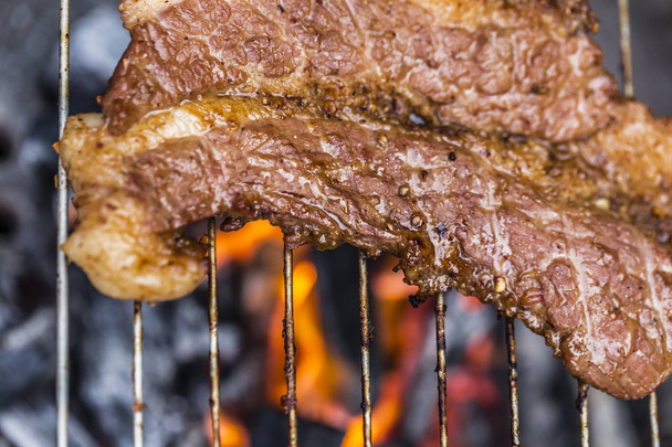 Grillen heerlijk varkensvlees op barbecue houtskool grill - Foto, afbeelding