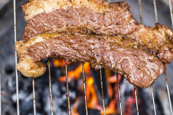 Grillen heerlijk varkensvlees op barbecue houtskool grill - Foto, afbeelding