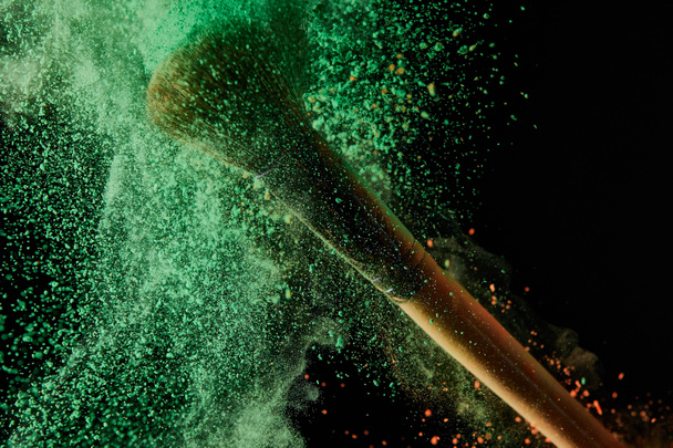 kozmetikai kefe zöld por robbanással fekete háttér - Fotó, kép
