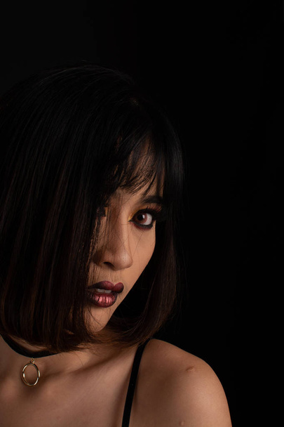 Southeast asian woman with dark tone makeup on black background, - Zdjęcie, obraz