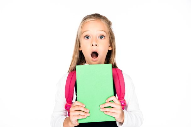 shocked schoolgirl holding book while looking at camera isolated on white - Fotoğraf, Görsel