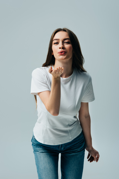 beautiful girl in white t-shirt blowing kiss isolated on grey - Foto, imagen