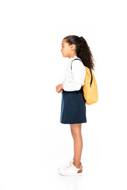 side view of african american schoolgirl with yellow backpack on white background - Фото, изображение