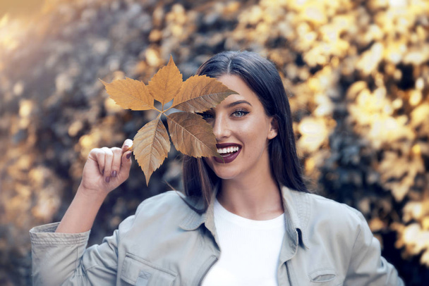 Young beautiful woman   posing  with leaf  - Foto, imagen
