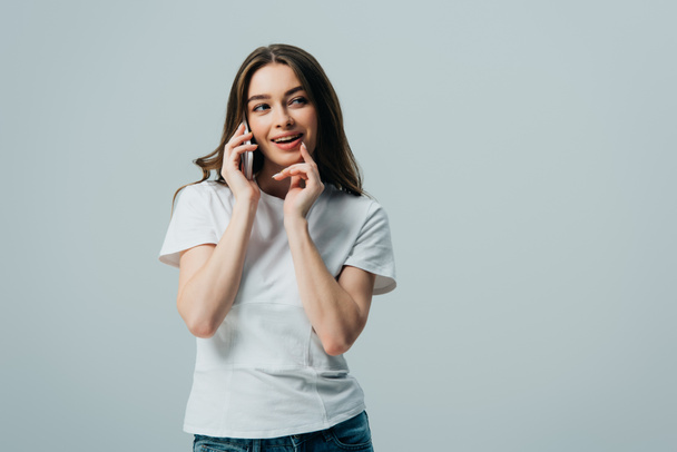 beyaz t-shirt kurnaz güzel kız gri izole akıllı telefon konuşuyor - Fotoğraf, Görsel