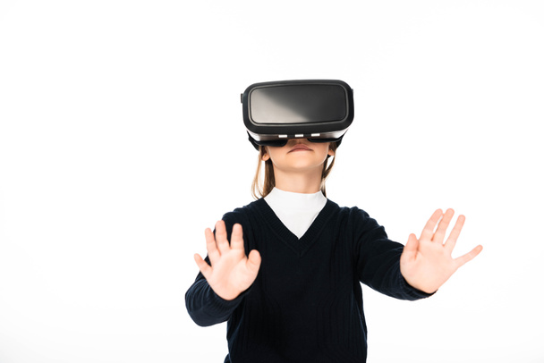 schoolgirl gesturing while using virtual reality headset isolated on white - Foto, imagen