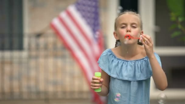 Mutlu amerikan kız köpük kabarcıklar üfleme, eğlenmek, mutlu çocukluk kavramı - Video, Çekim