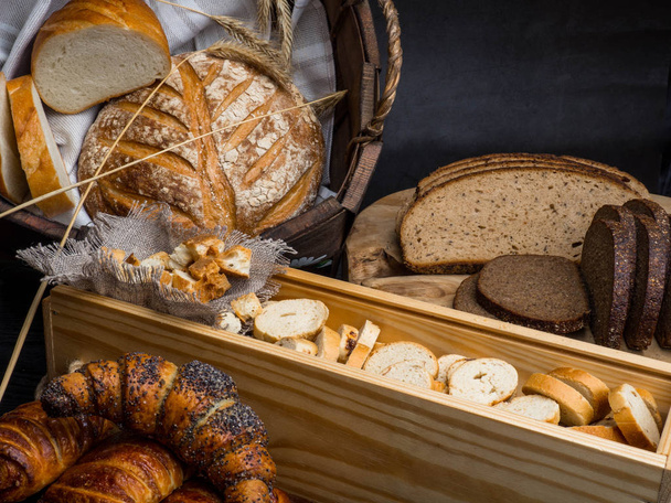 Různé druhy čerstvého chleba na dřevěném stole. Selektivní zaměření, mezera pro text - Fotografie, Obrázek