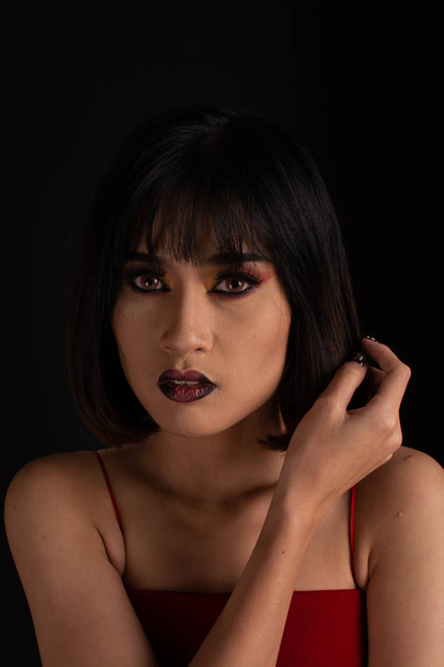 Southeast asian woman with dark tone makeup on black background, - Foto, afbeelding