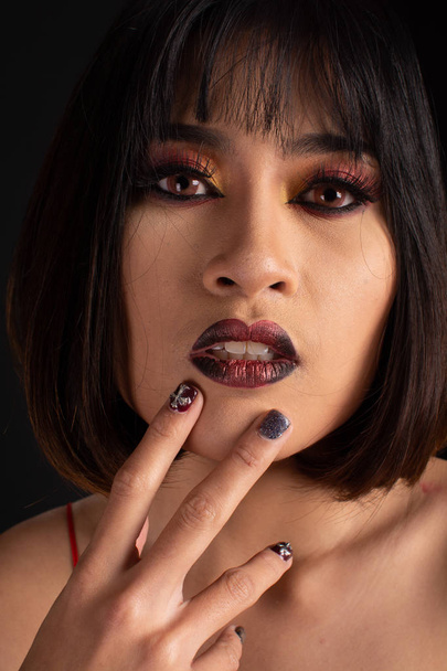 Southeast asian woman with dark tone makeup on black background, - Foto, imagen