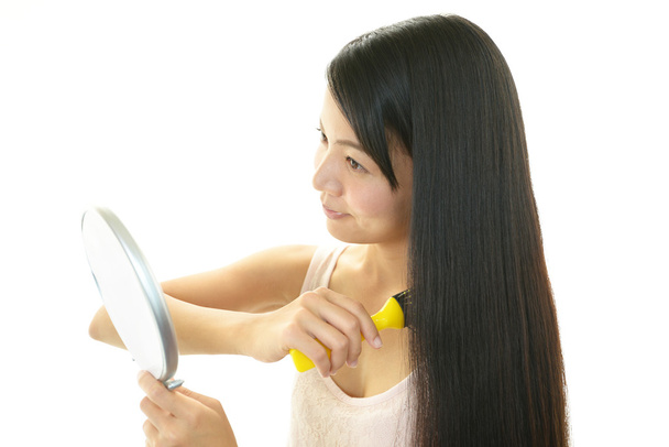 Young woman combing with a hairbrush - Foto, Bild