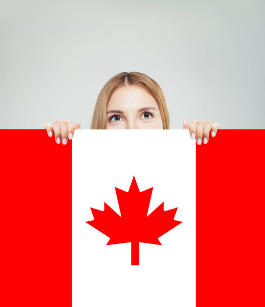 Boldog fiatal nő mutatja Kanada zászló háttérben. Élj, munka - Fotó, kép