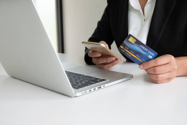 オンラインショッピングや支払いのためのクレジットカードを保有するビジネスウーマン消費者は、オンラインショッピングのためのクレジットカードを保持しているインターネットビジネスの女性消費者で購入を行います  - 写真・画像