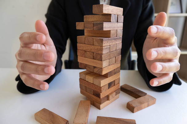 Hands prevent blocks wood, gambling placing wooden block. Concept Risk of management and strategy plan - Photo, Image