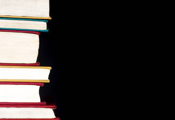 A stack of books isolated on a black background - Foto, Bild