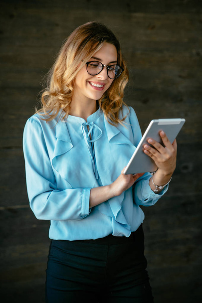 Cheerful businesswoman working on tablet - Photo, Image