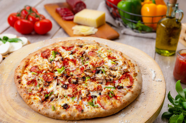 Delicioso estilo casero suprema pizza de verduras y carne en la cocina del restaurante con ingredientes completos
 - Foto, Imagen