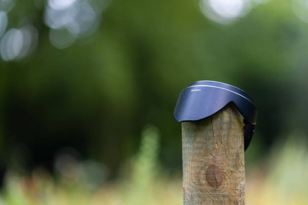 забытый солнцезащитный колпак на деревянном заборе
 - Фото, изображение
