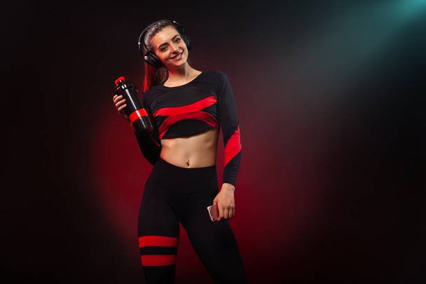 Sporty fit woman, athlete with dumbbells makes fitness exercising on red background. Fitness and workour motivation. - Foto, imagen