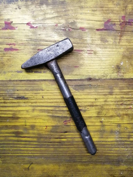 old iron hammer on a yellow wooden background shot by real natural close-up shot - Photo, Image