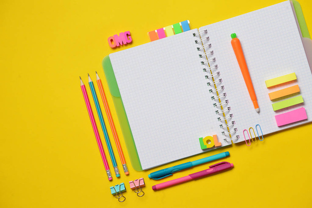 Colorful Back to School concept - open copy book with office and student supplies on yellow chalk. Space for text. - Fotografie, Obrázek