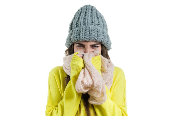 Closeup winter portret van vrouw in modieuze wollen gebreide muts, sjaal, trui en koude winter time, meisje bevroor. Witte achtergrond geïsoleerd - Foto, afbeelding