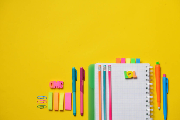 Colorful Back to School concept - open copy book with office and student supplies on yellow chalk. Space for text. - Foto, Imagem