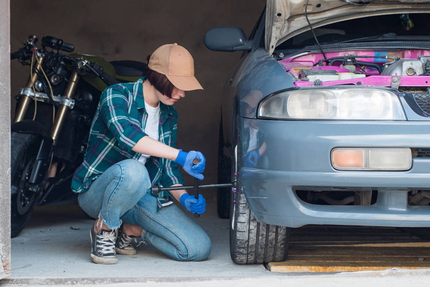 Femmina meccanico fissaggio auto in un garage
 - Foto, immagini