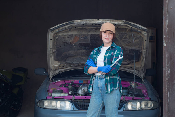 Vrouwelijke Mechanic Fixing auto in een garage - Foto, afbeelding