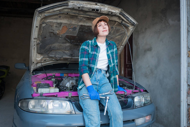 Mechanikerin repariert Auto in Garage - Foto, Bild