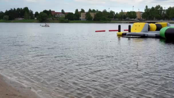 kleurrijke trampoline en boot op het water van het meer. Gimbal Motion shot - Video