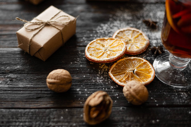 круглі скибочки сухого апельсина лежать на дерев'яному столі, подарунок в упаковці
 - Фото, зображення