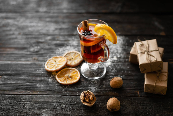Christmas mulled red wine with spices and fruits on a wooden rustic table. - Photo, image