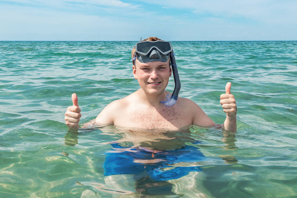 Funny man diver with snorkel equipment snorkeling mask and tube in ocean. Summer vacation swimming fun concept. - Φωτογραφία, εικόνα