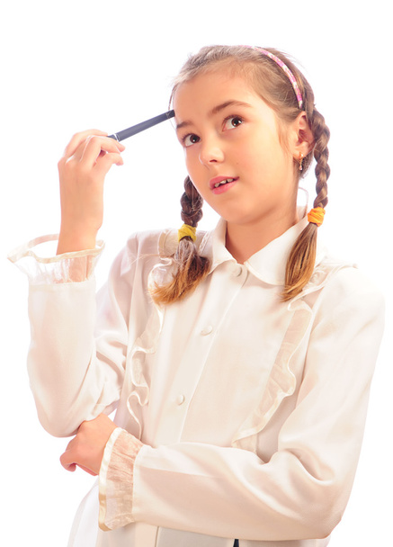 Schoolgirl holds a pen at a forehead - Фото, изображение