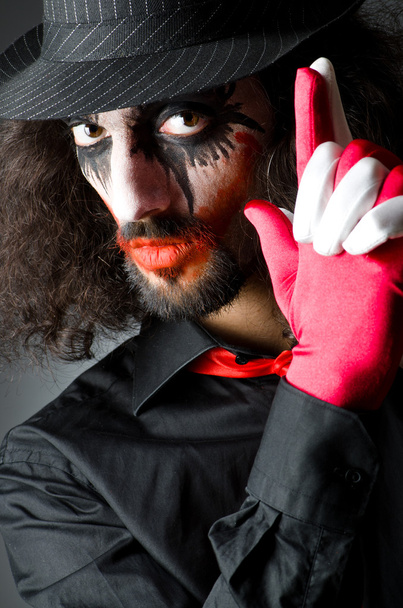 Joker personificatie met man in donkere kamer - Foto, afbeelding