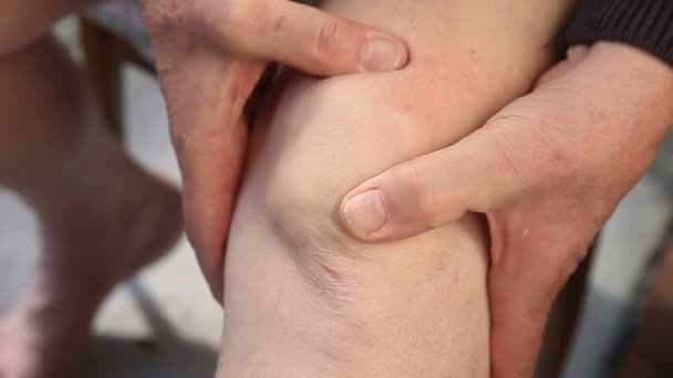 Egy férfi ellenőrzi a fájdalom a könyökét. - Felvétel, videó