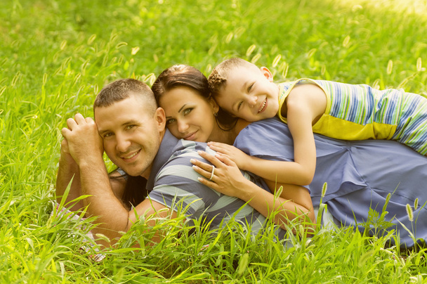 Happy family lying down in the garden - Photo, Image