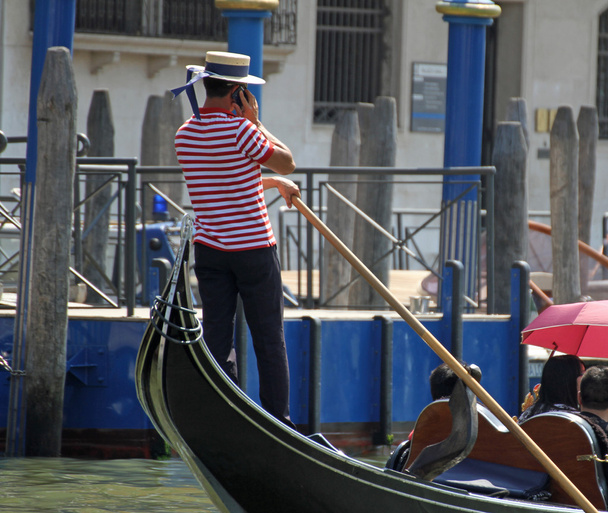 Skilled Venetian gondolier pilot his gondola while talking to ph - Fotografie, Obrázek