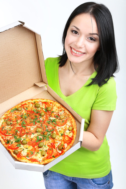 Beautiful girl with delicious pizza in pizza box isolated on white - 写真・画像