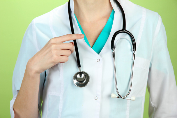 Medical doctor with stethoscope, on color background - Φωτογραφία, εικόνα